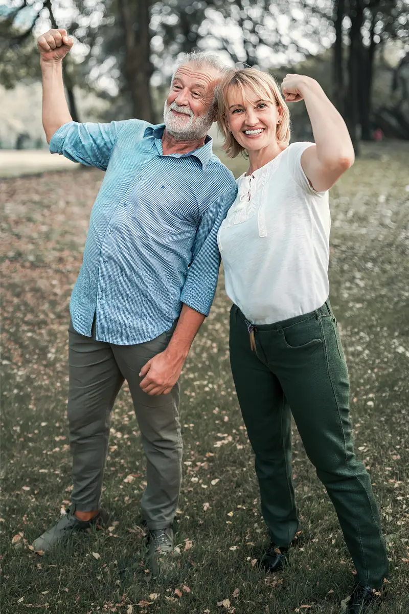 Un couple agé montre les muscles en souriant
